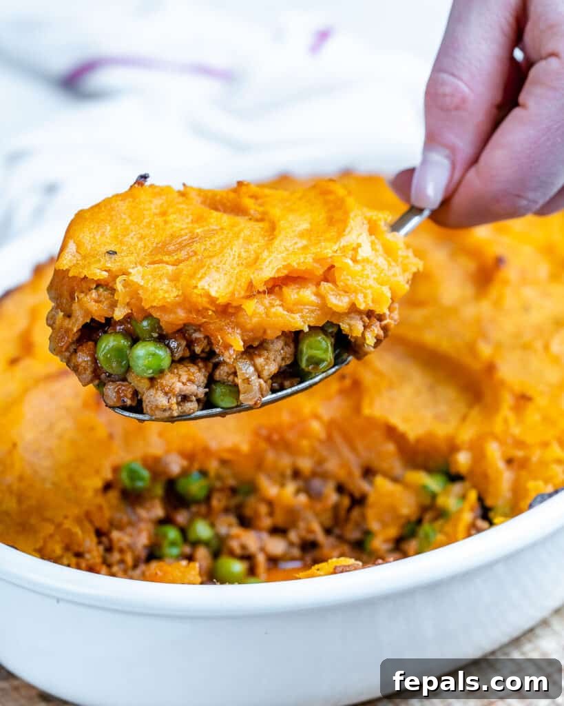 Wholesome Sweet Potato Shepherd's Pie 4 side shot of a spoon full of sweet potato shepherd's pie over a dish