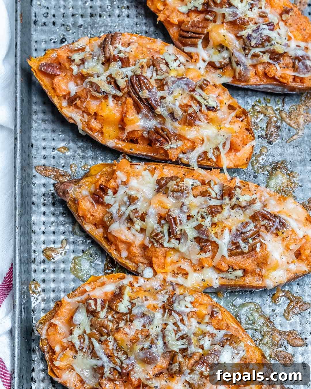 Ultimate Twice-Baked Sweet Potatoes 7 Four beautifully golden-brown baked sweet potatoes on a sheet pan, ready to be prepared for the next step of the twice-baked process.