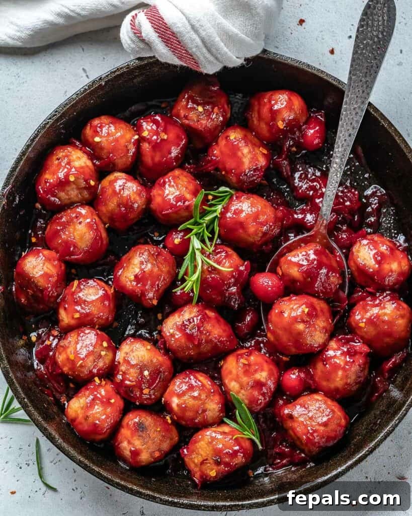 top view of a black skillet with chicken meatballs in cranberry sauce with soon in skillet