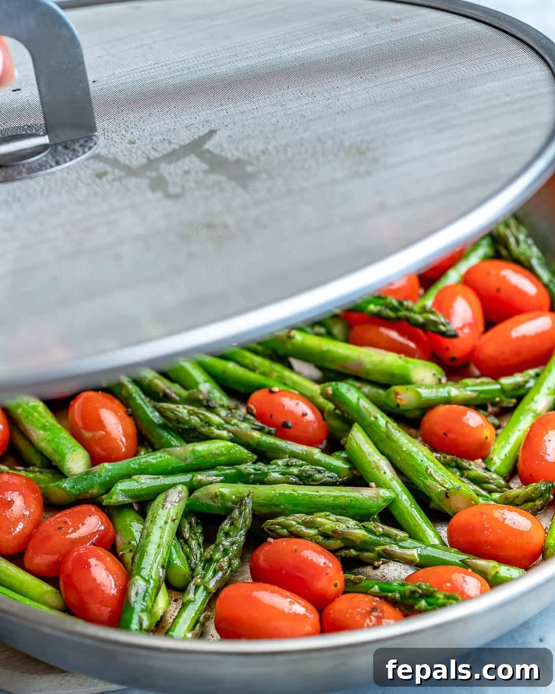 Spring Chicken Asparagus Pasta 4 Vibrant asparagus spears and red cherry tomatoes sizzling in a pan with olive oil.