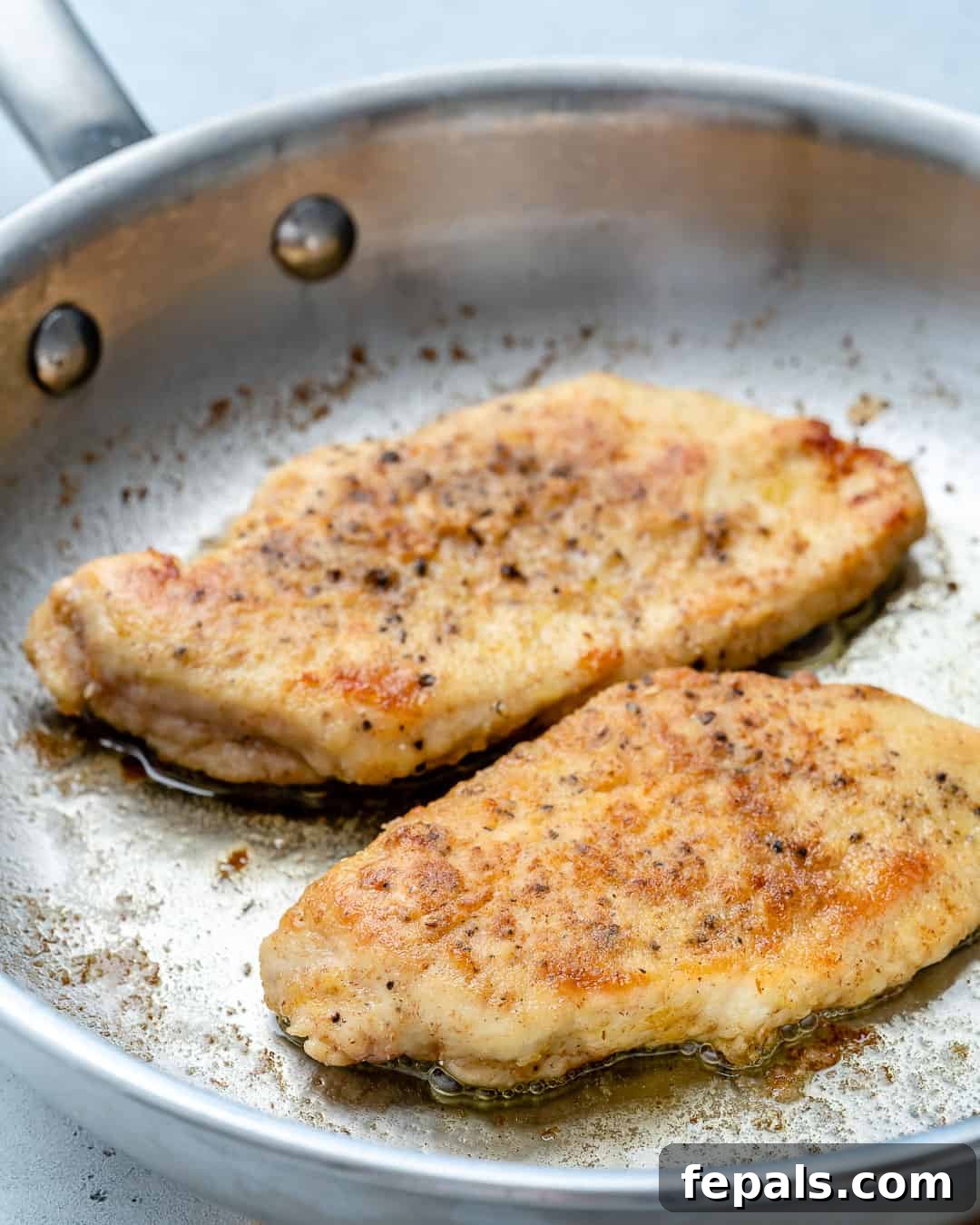Effortless Creamy Chicken Piccata 4 seared chicken breast on a skillet.