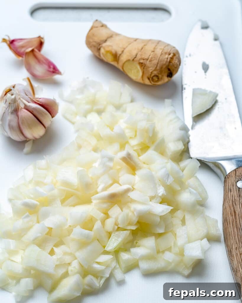 Quick & Creamy Butter Chicken 4 chopped onions, fresh ginger, and garlic on a cutting board