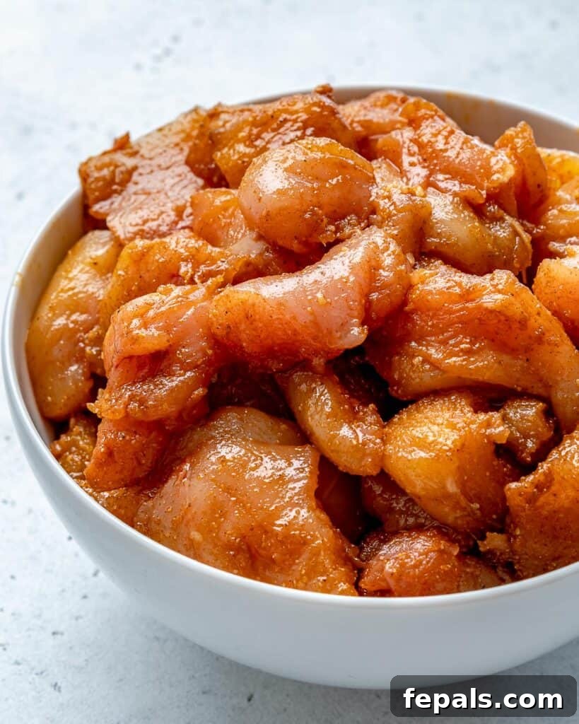 Quick & Creamy Butter Chicken 5 marinated raw chicken chunks in a round white bowl