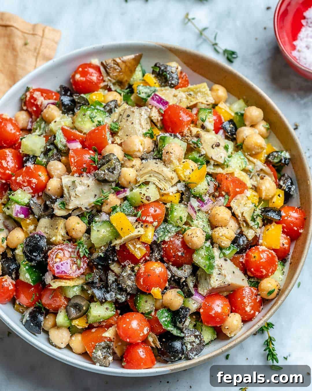 Easy and healthy chickpea salad recipe with olives, feta cheese, and artichoke hearts.
