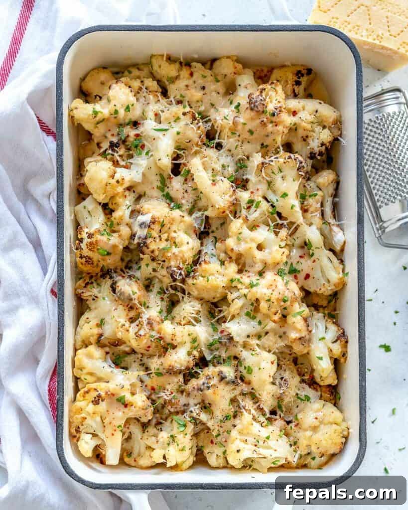 top view of a white baling dish with creamy and cheesy baked cauliflower florets
