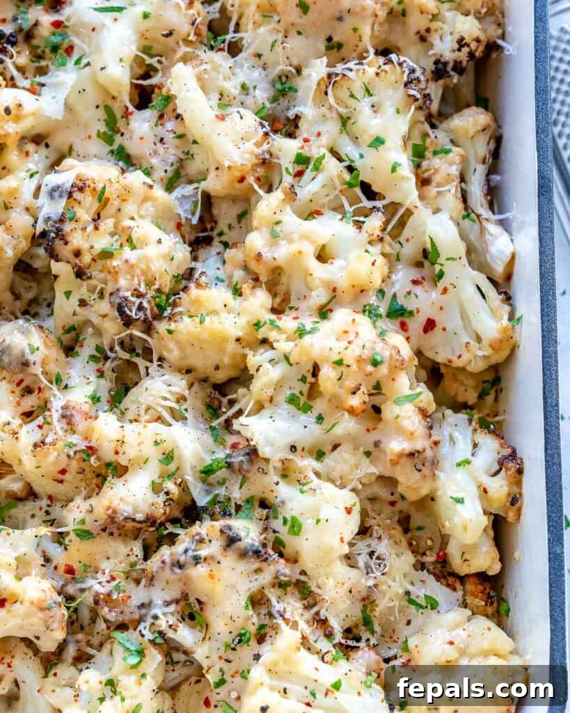 top view of a cheesy baked cauliflower casserole in a dish garnished with parsley