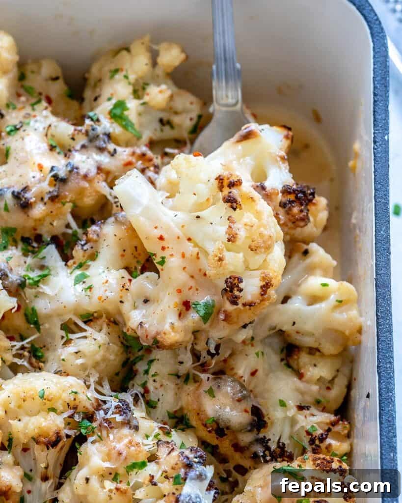 close up of a dish with baked cauliflower florets that's garnished with pepper flakes and parsley