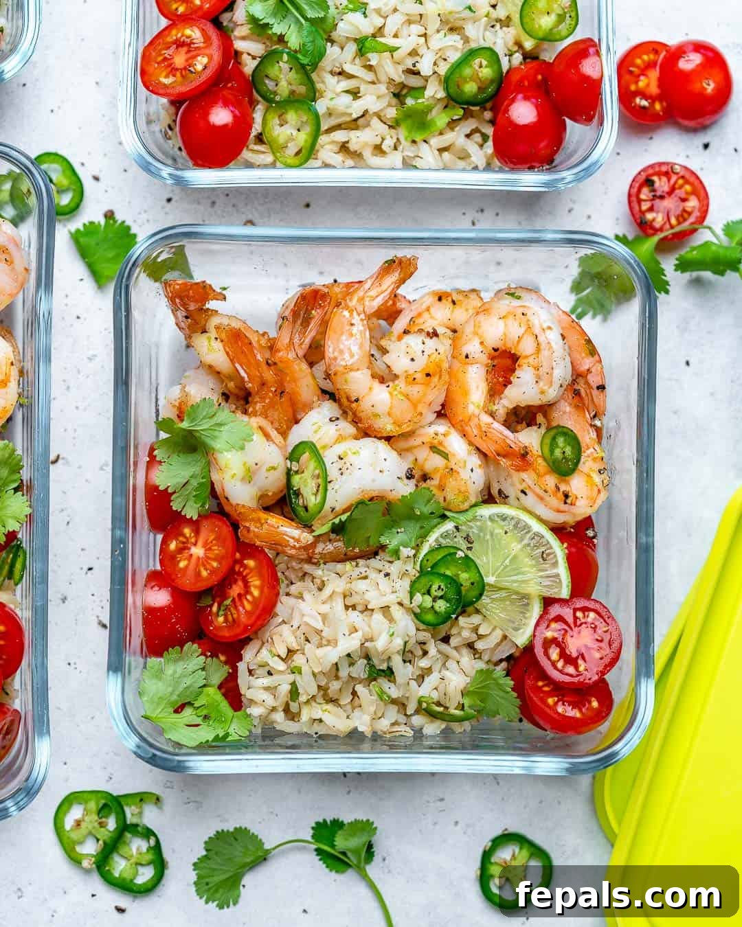 Savory Garlic Shrimp Meal Prep 4 A beautifully presented meal prep container filled with tender sautéed shrimp, vibrant cilantro lime rice, and fresh cherry tomatoes, ready for a healthy and convenient meal.