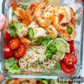 Flavorful Garlic Shrimp Meal Prep 8 a meal prep bowl with sauteed shrimp, brown rice, and chopped tomatoes.