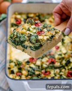 A portion of baked eggs and veggies on a spatula.