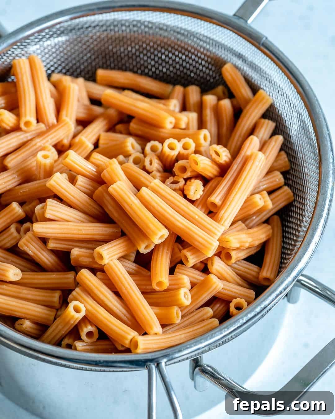 Lentil pasta in a colander, freshly rinsed and cooled for pasta salad