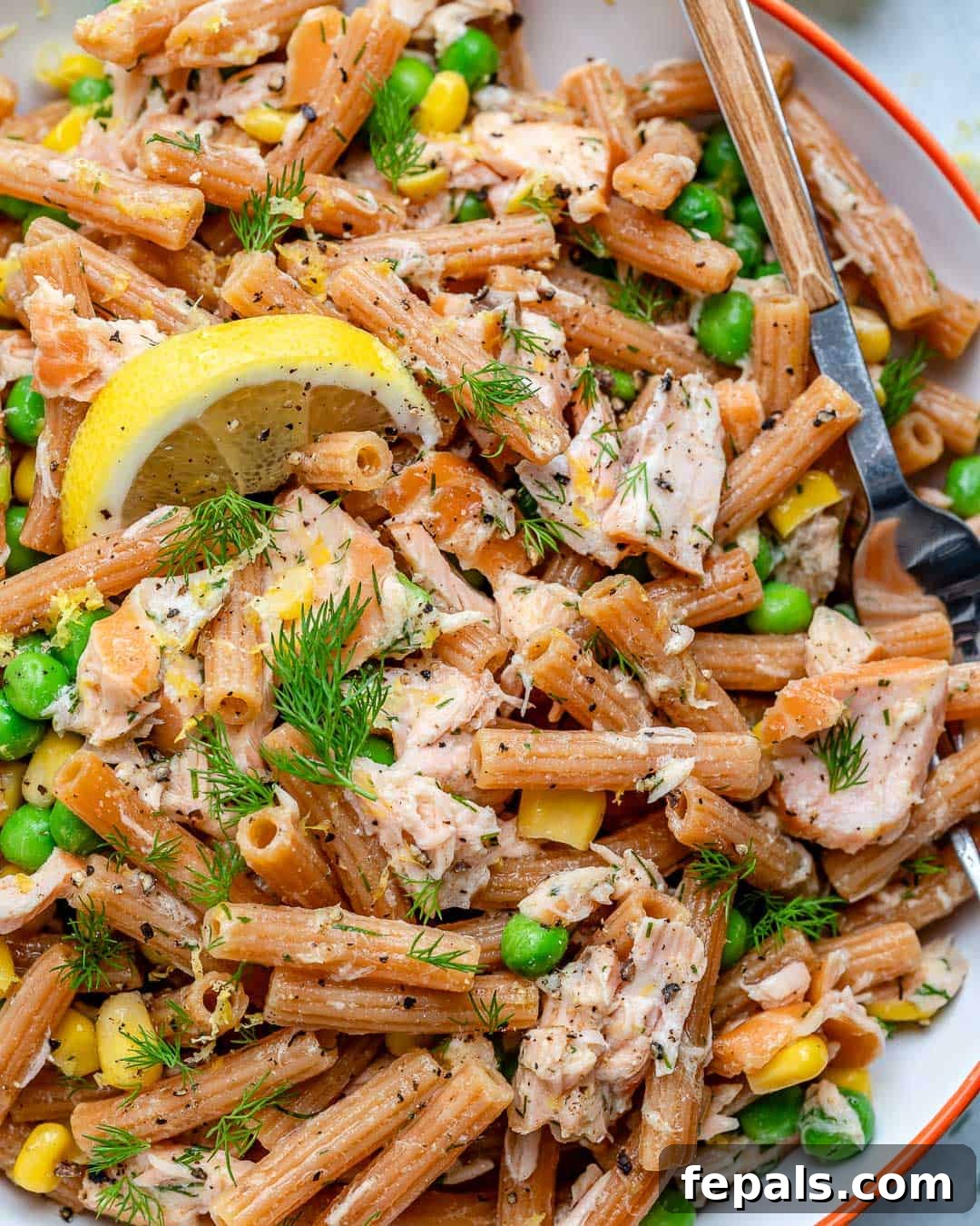 Pasta salad with smoked salmon, peas, corn, fresh dill, and zesty dressing served in a large bowl