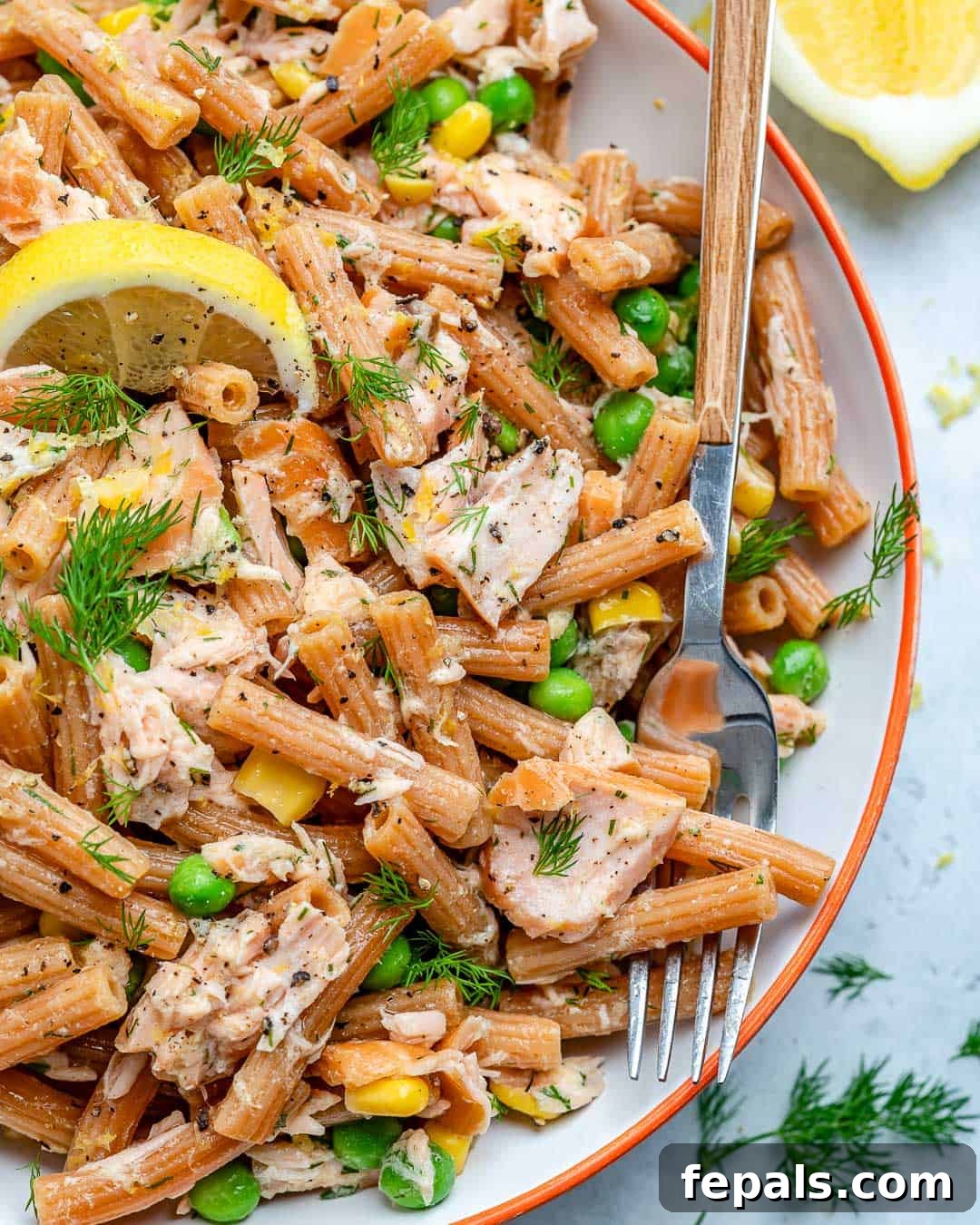Smoked salmon and pasta salad in a rustic bowl, garnished with fresh dill