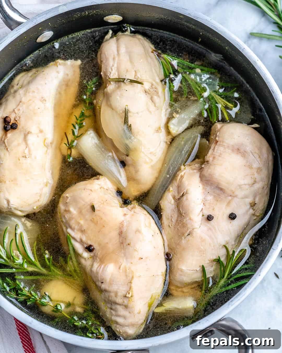 Perfectly Poached Chicken Every Time 2 Poached chicken in pot with broth and herbs