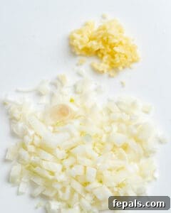 Diced onion and garlic on cutting board.