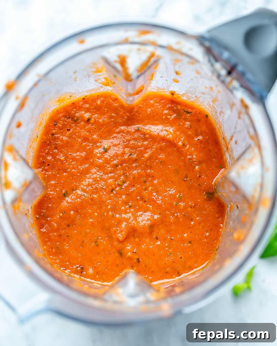 Freshly blended homemade marinara sauce in a blender, ready to be poured.