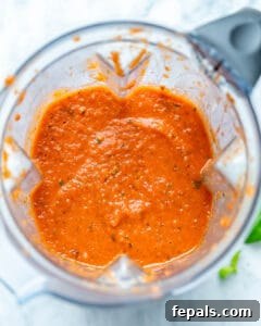 Creamy marinara sauce being blended in a high-speed blender.