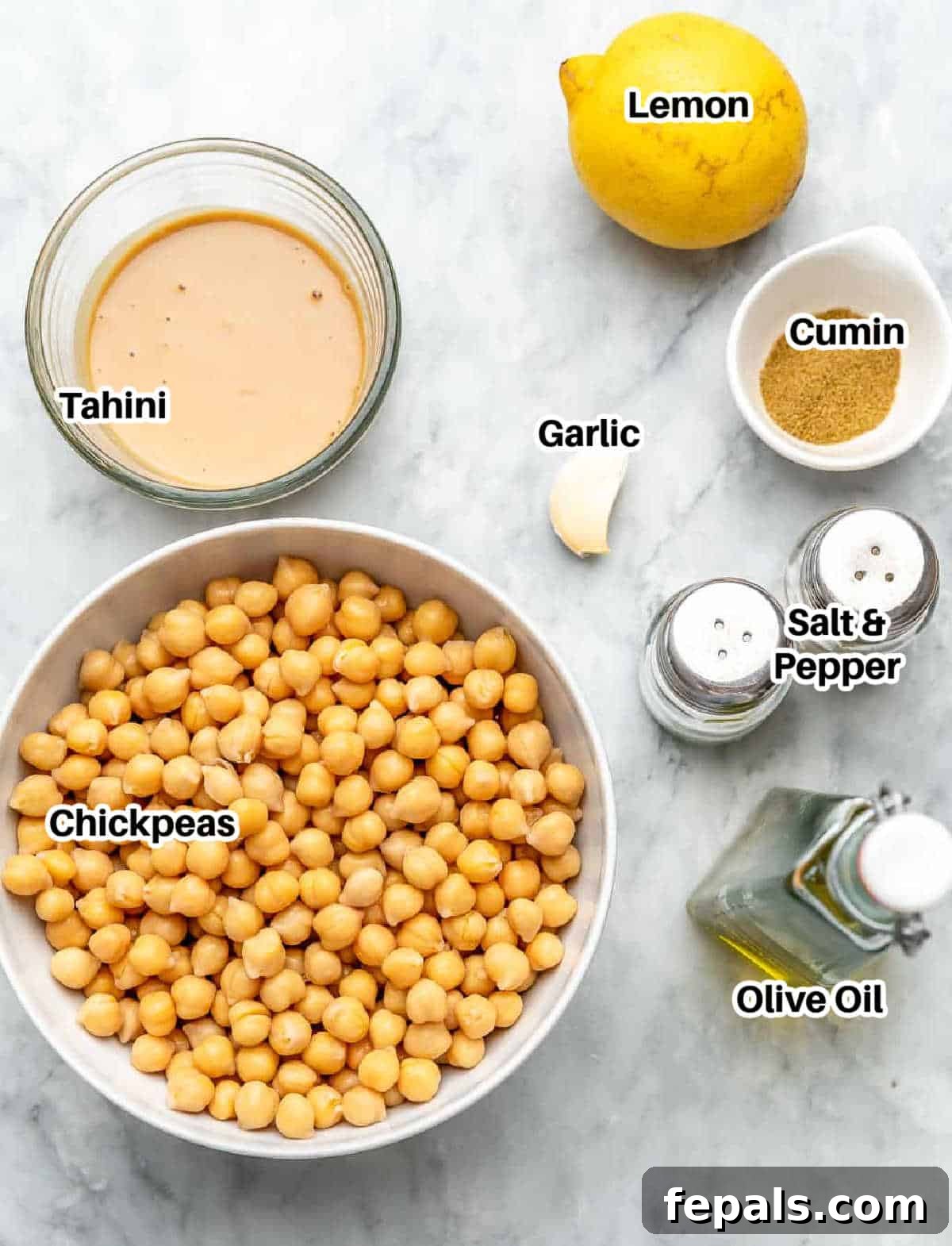Simple Steps to Creamy Homemade Hummus 3 A selection of fresh ingredients needed to make homemade hummus including chickpeas, tahini, lemon, garlic, and olive oil.
