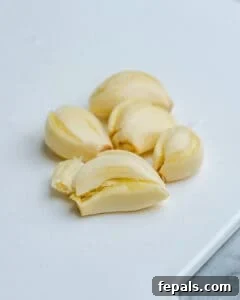 Healthy and Delicious Cauliflower Alfredo Sauce 13 crushed garlic on cutting board