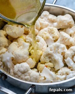 Healthy and Delicious Cauliflower Alfredo Sauce 15 pouring broth over cauliflower florets in pan to cook