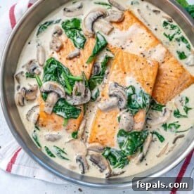 Salmon florentine recipe with spinach and mushrooms in a round silver pan.