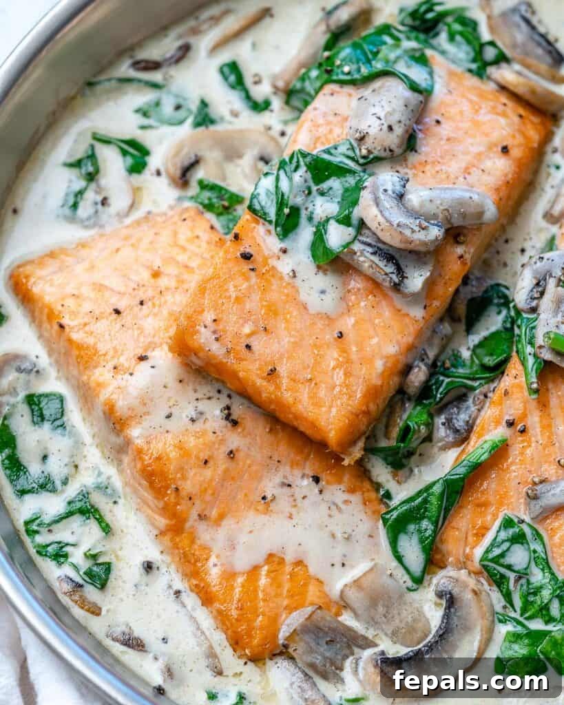Effortless Salmon Florentine 6 close up of cooked salmon filets in a creamy white sauce in a pan