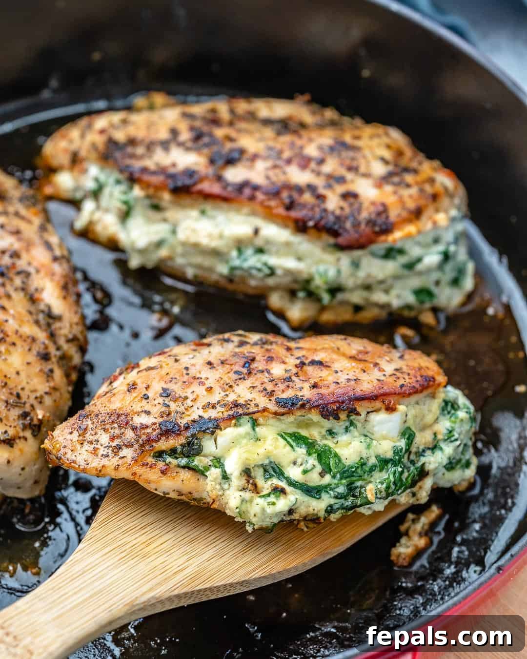 Creamy Spinach and Cheese Stuffed Chicken 11 Healthy stuffed chicken recipe with spinach and cheese, garnished on a white plate.