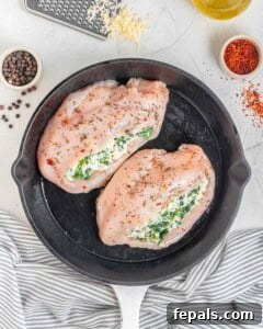 Two stuffed chicken breasts placed in a skillet.