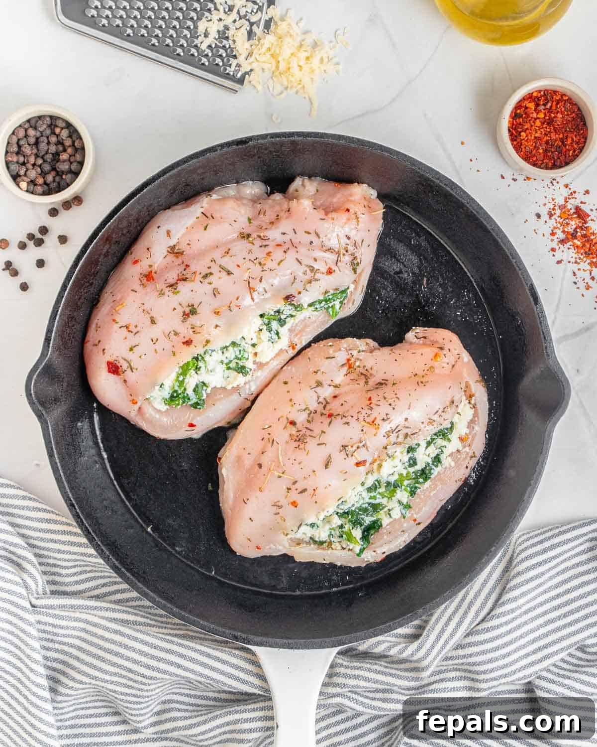 Creamy Spinach and Cheese Stuffed Chicken 8 Two stuffed chicken breasts placed in a skillet, ready for baking.