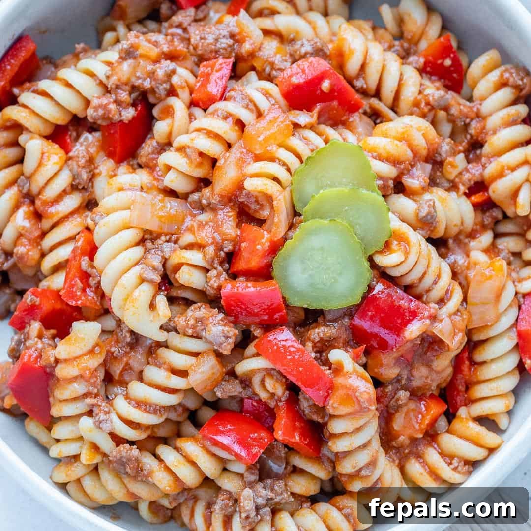 One-Pot Cheeseburger Pasta 3 Close-up top view of delicious cheeseburger pasta in a white bowl, showing melted cheese and rich sauce.