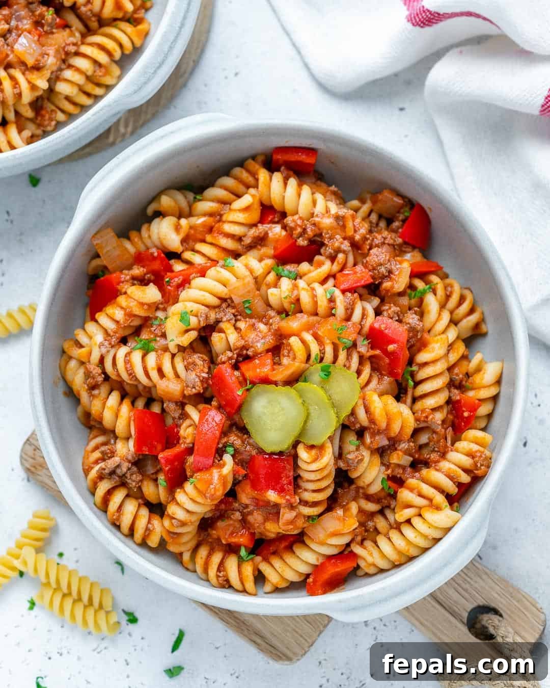 One-Pot Cheeseburger Pasta 4 Top view of delicious cheeseburger pasta served in a white bowl, garnished with fresh herbs.