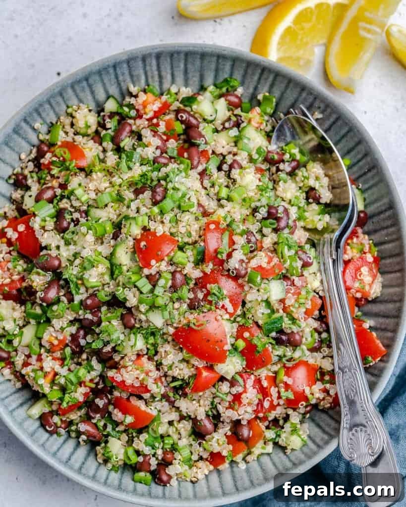 Vibrant Quinoa Black Bean Herb Bowl 2 top view of tabbouleh on a blue plate with spoon in plate on the right side