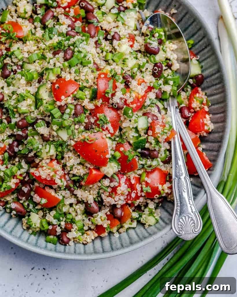 Vibrant Quinoa Black Bean Herb Bowl 9 top view of tabbouleh on blue plate with spoon and fork in salad