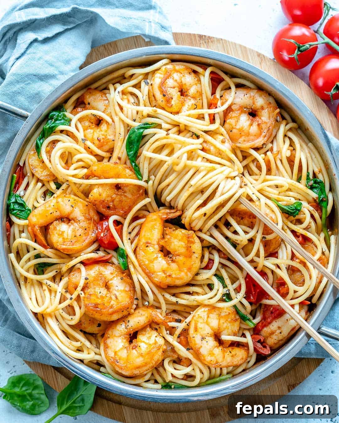 An inviting overhead shot of Garlic Shrimp Spaghetti, showcasing a generous portion of pasta, bright red cherry tomatoes, and perfectly cooked shrimp.