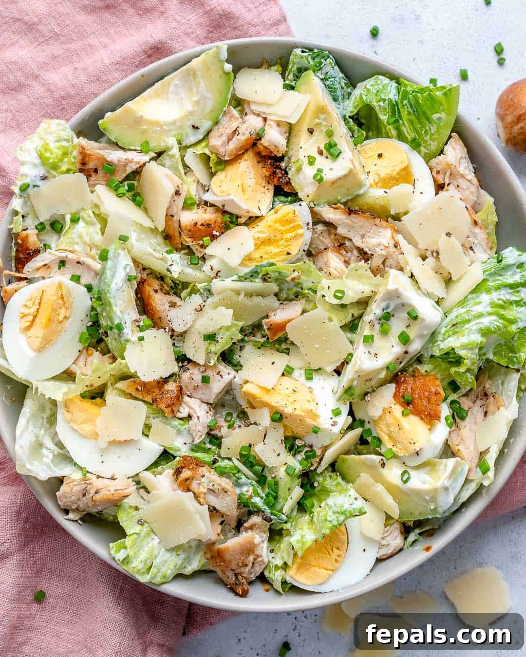 Guilt-Free Chicken Caesar Salad 3 salad bowl top view with pink napkin on the left