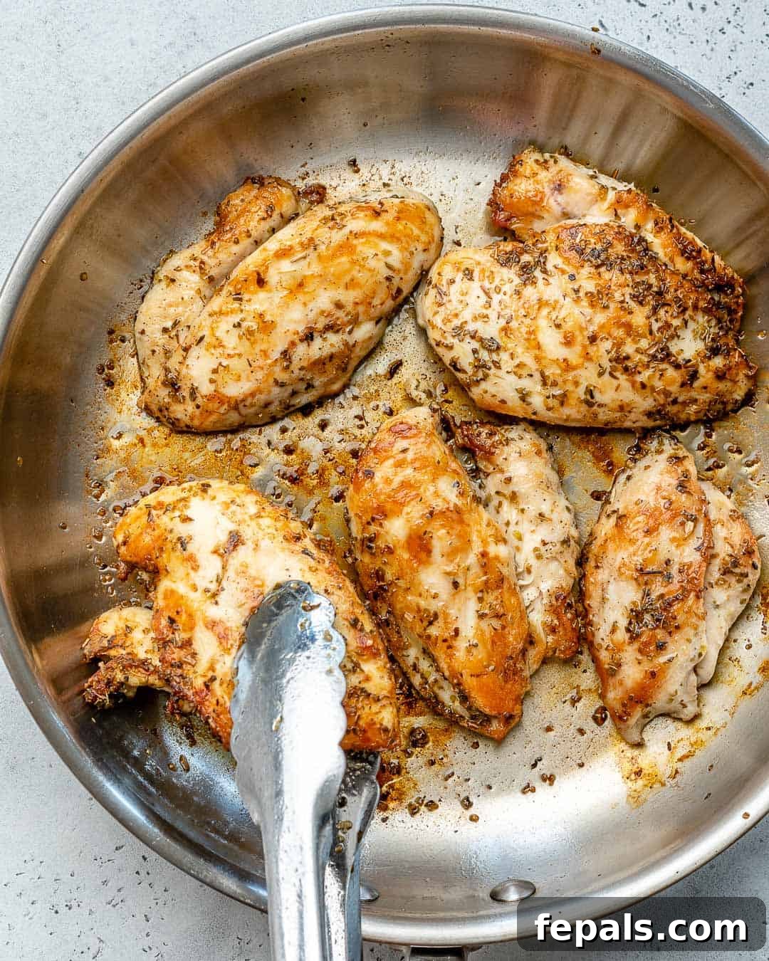 Guilt-Free Chicken Caesar Salad 4 cooking chicken in a pan to make chicken caesar salad.