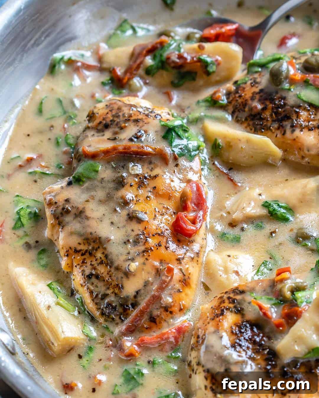 Creamy Tuscan Chicken Delight 5 Close-up of perfectly seared creamy Tuscan chicken breasts generously coated in a rich, vibrant sauce with sun-dried tomatoes and spinach.
