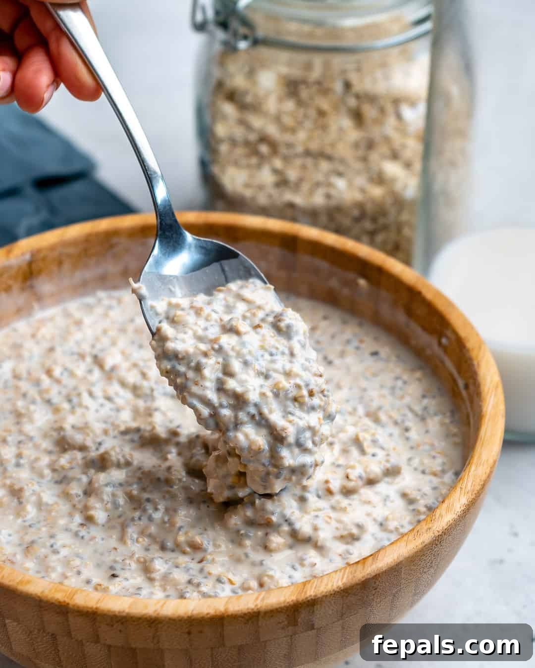 Effortless Greek Yogurt Overnight Oats 5 A spoon stirring mixed oatmeal and Greek yogurt in a bowl, demonstrating the preparation of overnight oats.