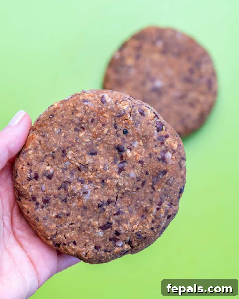 hand holding black bean patty before cooking