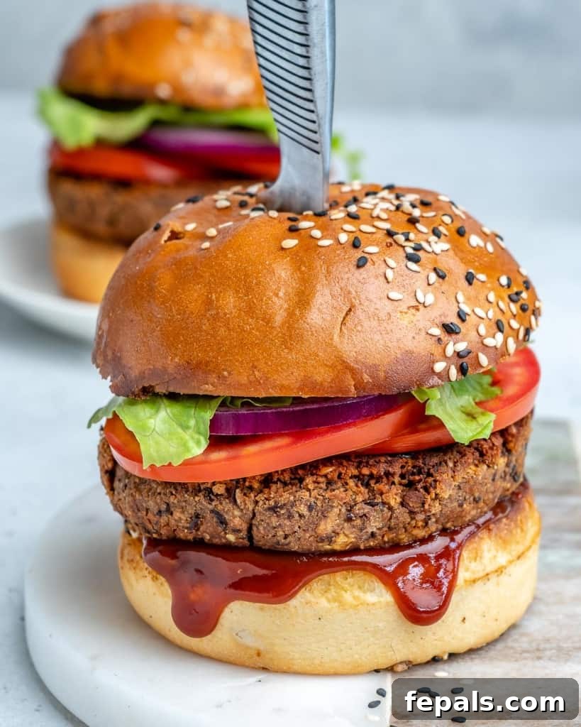 knife in the middle of a black bean burger with bbq sauce dripping out