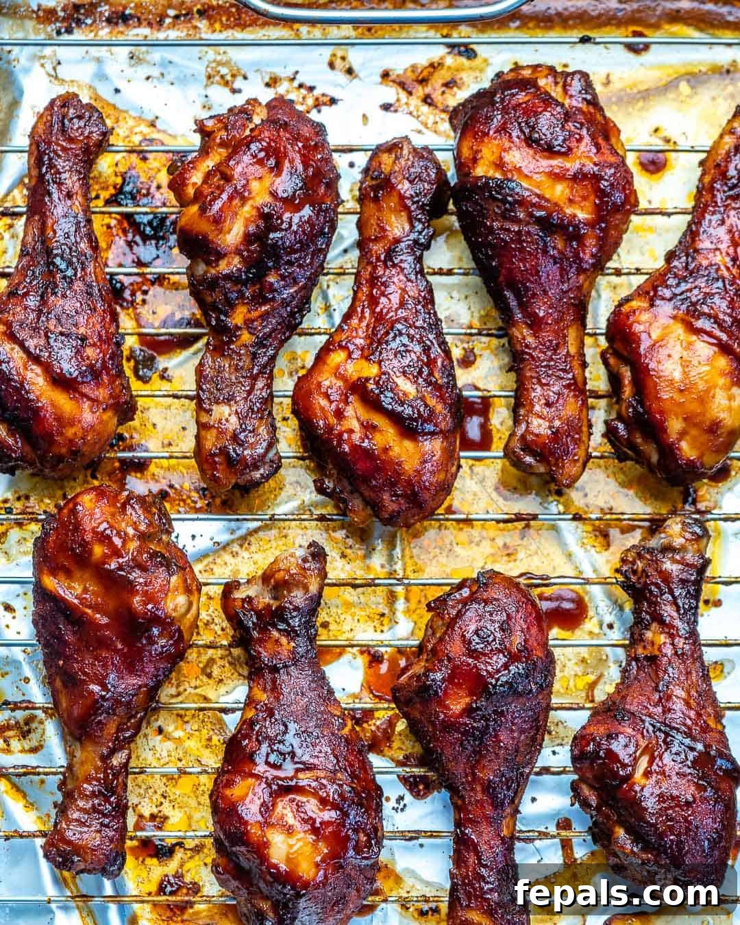 A top-down view of two baked BBQ chicken drumsticks presented side by side, emphasizing their perfectly cooked appearance and readiness for serving.