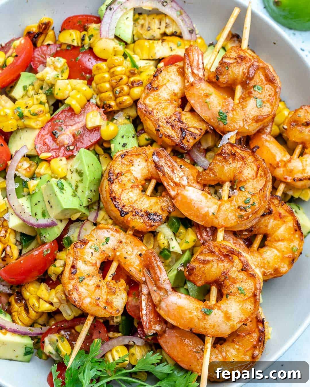 Zesty Shrimp Avocado Corn Salad 8 corn salad in a white bowl topped with grilled shrimp