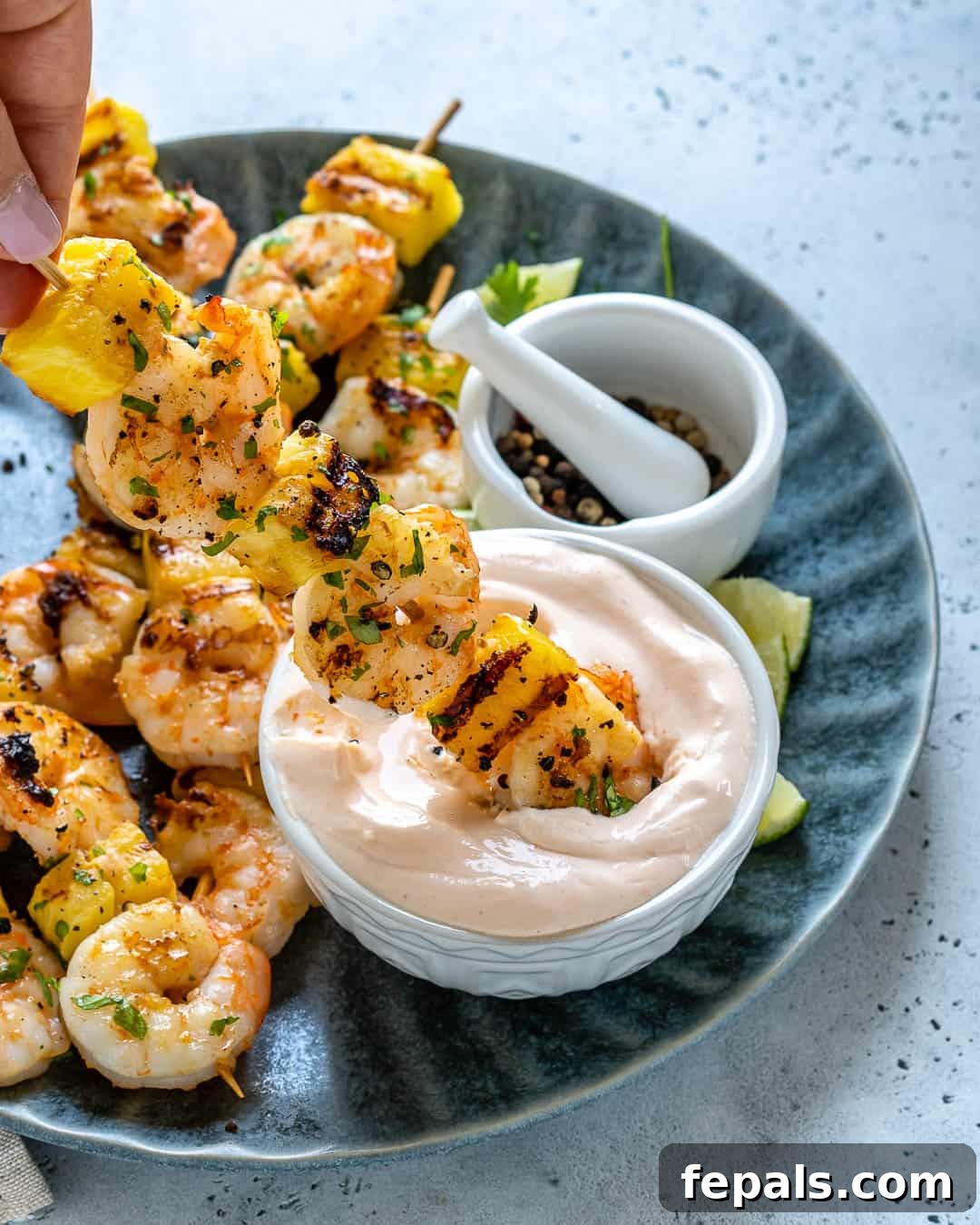 pineapple shrimp skewer dipped in yogurt bowl