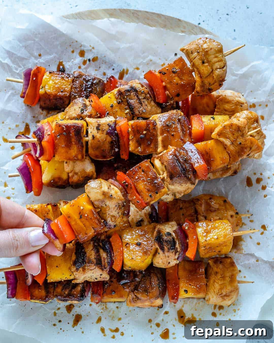 Sweet and Savory Pineapple Chicken Skewers 6 hand holding a chicken skewer