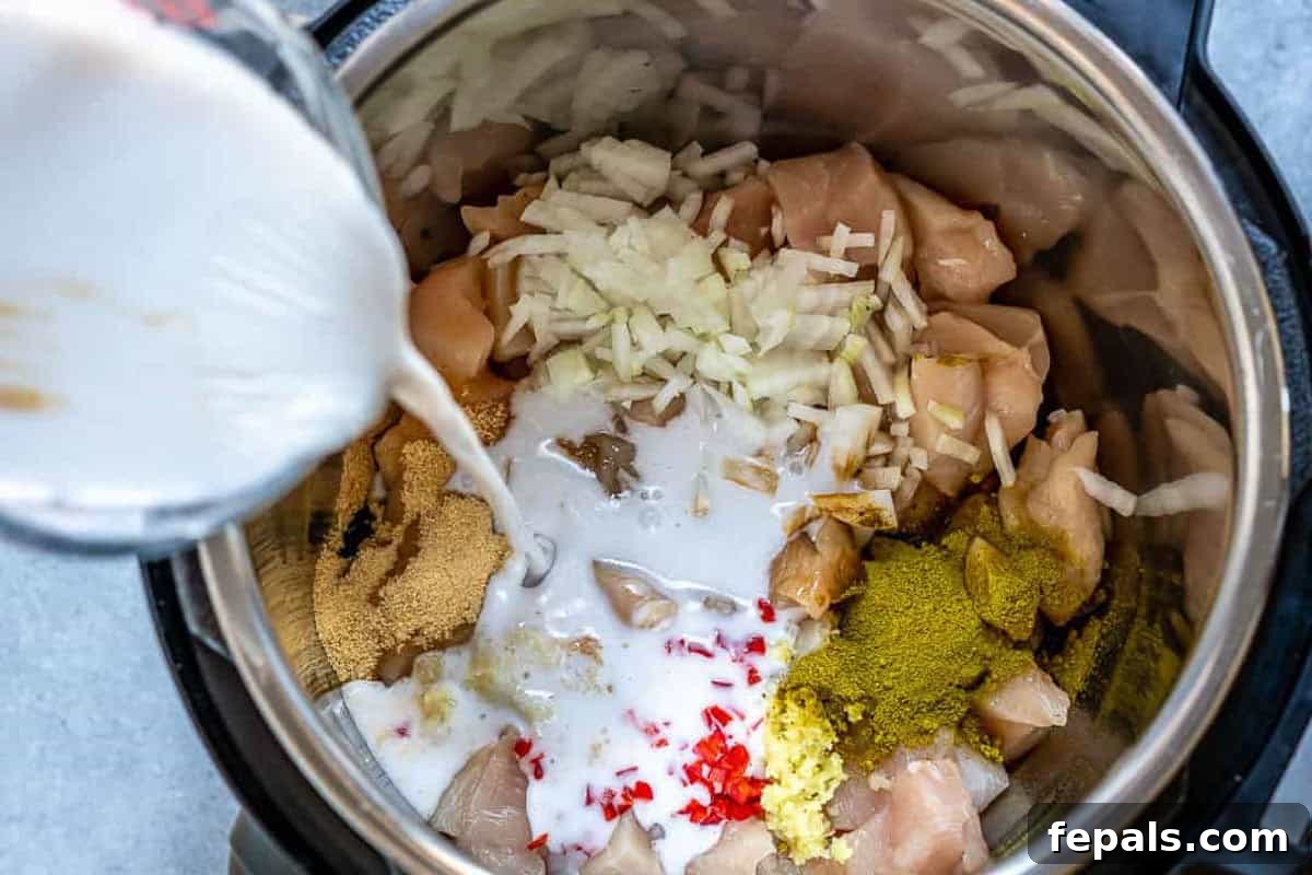 Simple Dairy-Free Instant Pot Chicken Curry 4 Pouring rich coconut milk into the Instant Pot, mixing with chicken and other curry ingredients.