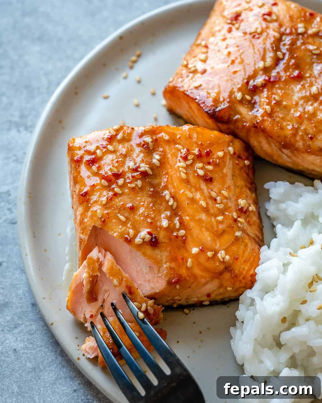 Airfryer'da Nar Gibi Kızarmış Ballı Somon 2 Fork with tender piece of honey glazed air fryer salmon, showcasing its flaky texture and golden glaze.