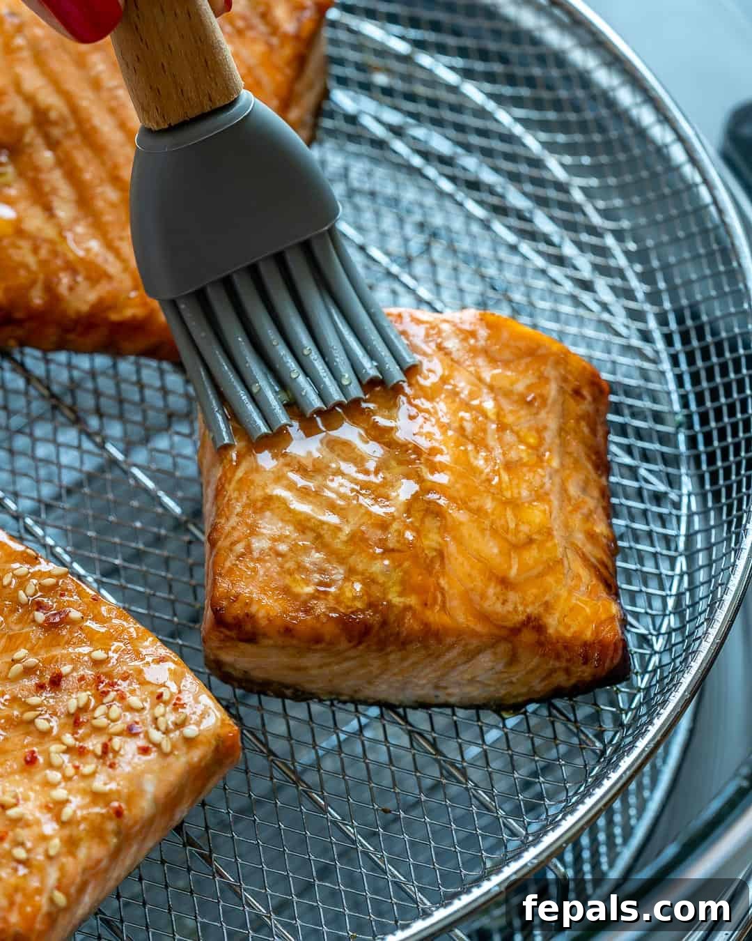 Airfryer'da Nar Gibi Kızarmış Ballı Somon 7 Brushing the salmon fillets with a generous layer of honey during the air frying process to create a sweet glaze.