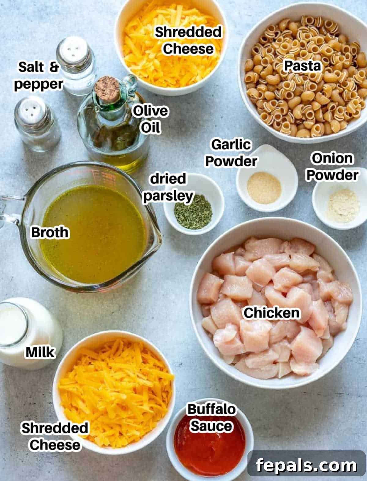 Spicy Buffalo Chicken Macaroni Bake 4 Arrangement of ingredients for making buffalo mac and cheese, including chicken, pasta, cheese, and spices.