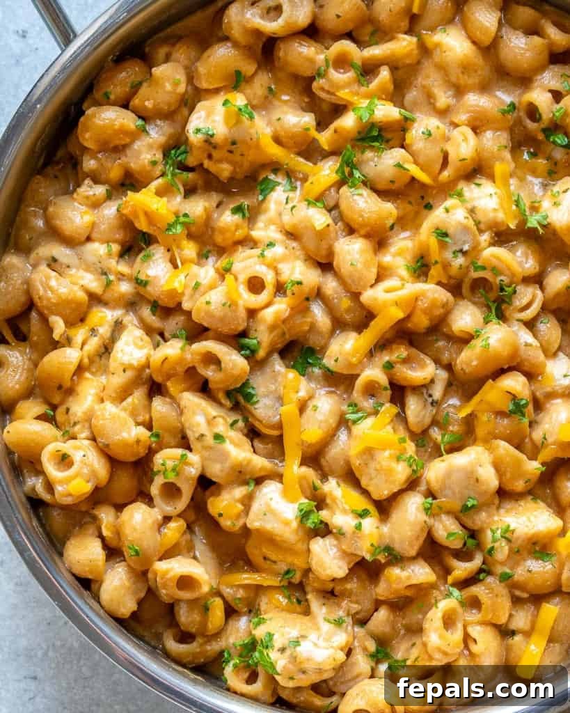 Spicy Buffalo Chicken Macaroni Bake 7 Close-up top view of buffalo chicken mac and cheese in a skillet, showcasing the melted cheese and chicken.