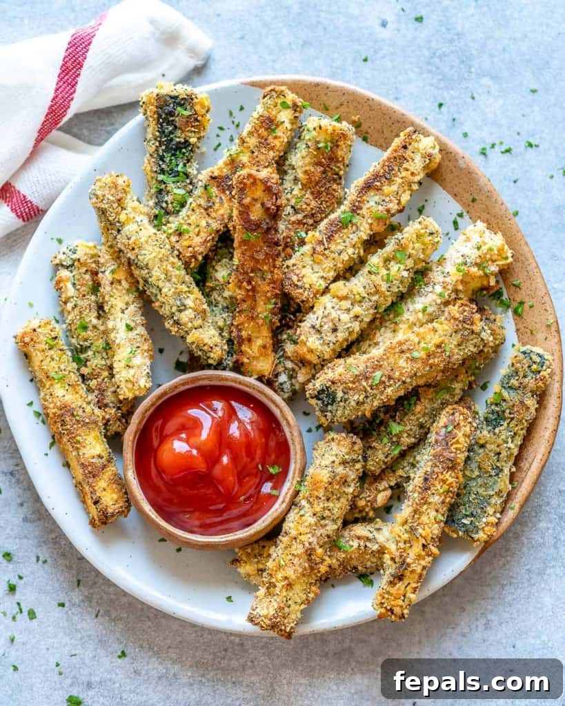 Parmesan-Crusted Zucchini Fries 2 top view of baked zucchini fries on a plate with a side of ketchup